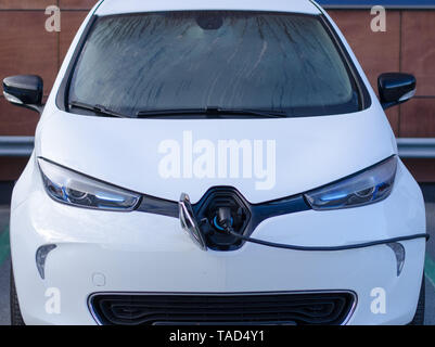 Stockholm, Schweden, 14. Mai 2019. Das e-Auto Renault Zoe in einem Parkplatz Aufladen der Batterie an einem regnerischen Tag. Stockfoto