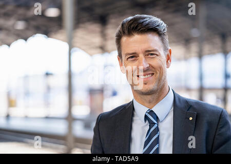 Portrait von lächelnden Geschäftsmann am Bahnsteig Stockfoto