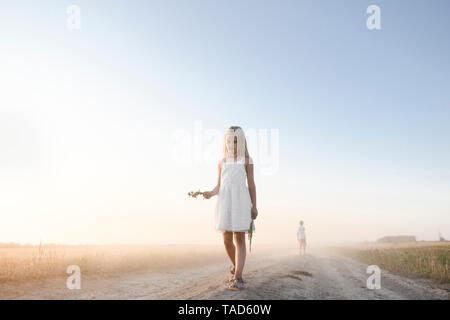 Mädchen gehen auf eine ländliche Feldweg Stockfoto