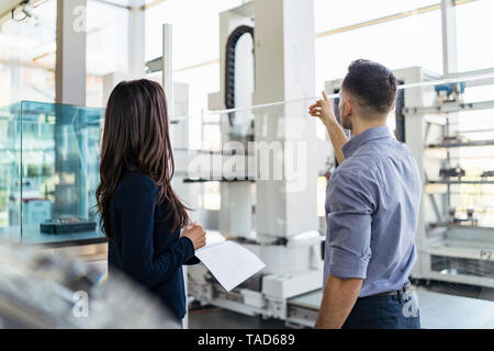 Ansicht der Rückseite des Geschäftsmann und Geschäftsfrau sprechen in der modernen Fabrik Stockfoto