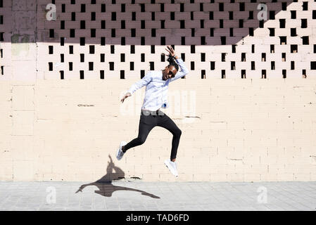 Glücklicher junger Mann in die Luft springen Stockfoto
