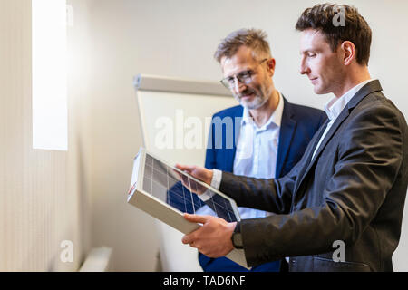 Zwei Geschäftsleute in Office mit Solarzelle diskutieren Stockfoto
