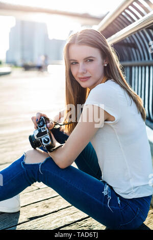 Junge Frau in New York City, die Bilder an der Brooklyn Bridge Stockfoto