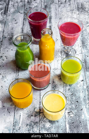 Verschiedene bunte Smoothies in Gläsern und Flaschen Stockfoto
