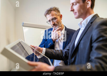 Zwei Geschäftsleute im Büro auf der Suche nach Solarzellen Stockfoto