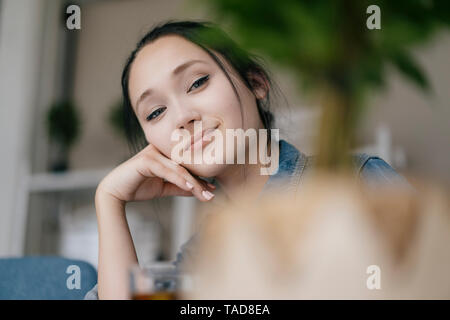 Portrait von lächelnden jungen Frau hinter einer Anlage Stockfoto