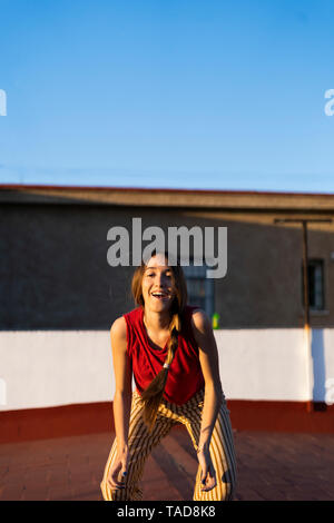 Portrait von Happy Teenager auf dem Dach Terrasse bei Sonnenuntergang Stockfoto