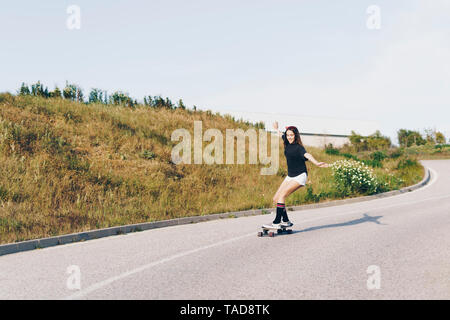 Spanien, junges Mädchen reiten Skateboard hinunter eine Straße Stockfoto