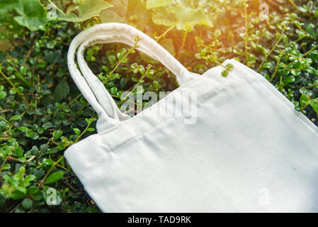 White canvas Stoff eco Beutel Tuch shopping Sack tote auf grünem Blatt Natur Hintergrund/Null Abfall Verwenden weniger Kunststoff sagen keine Plastiktüte Verschmutzung üblichen Fehlermeldungsprozeduren Stockfoto