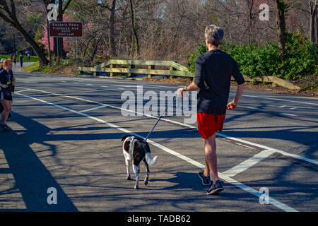 Ein Mann ist Jogging im Park mit seinem Hund. Stockfoto