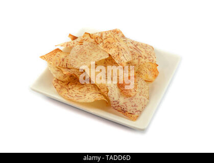 Taro slice knusprig gebraten auf Platte auf weißem Hintergrund/Taro Chips für Snack isoliert Stockfoto