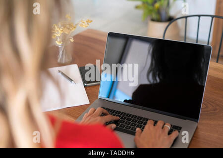 In der Nähe von Frau mit Laptop auf dem Holztisch zu Hause Stockfoto