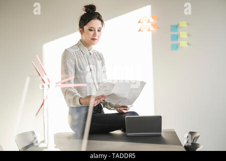 Im Büro lesen Plan mit Wea-Modelle auf dem Schreibtisch Geschäftsfrau Stockfoto