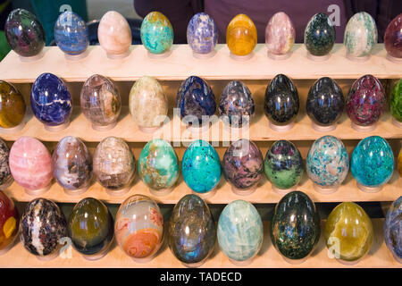 Verschiedenen bunten stein Eier auf einem hölzernen Gestell an der Mineralienausstellung angeordnet Stockfoto