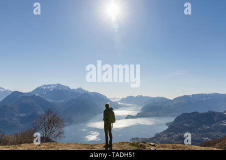 Italien, Como, Lecco, Frau auf einer Wanderung in den Bergen über den Comer See und die Aussicht geniessen Stockfoto