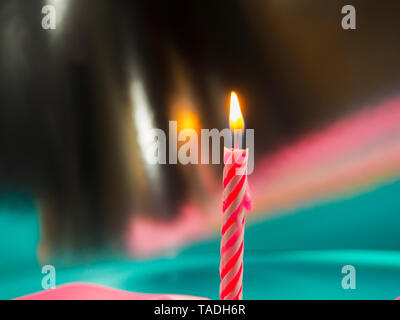 Kerze zum Geburtstag Brennen im Hintergrund andere Kerzen, rosafarbenen Bändern, festliche Atmosphäre Stockfoto