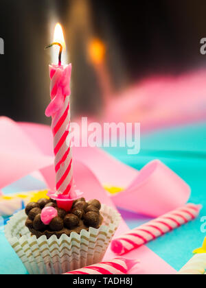 Kerze zum Geburtstag Brennen im Hintergrund andere Kerzen, rosafarbenen Bändern, festliche Atmosphäre Stockfoto