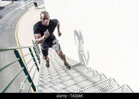 Mann in Schwarz Sportswear bis Treppe Stockfoto