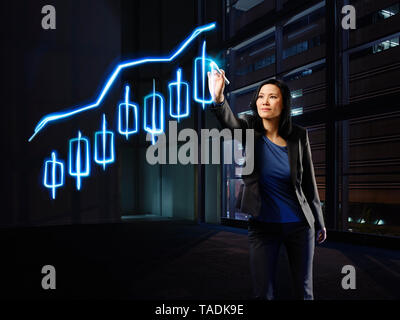 Asiatische Geschäftsfrau Malerei candle stick Chart mit Licht Stockfoto