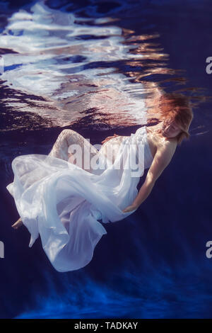 Schwangere Frau tragen weiße Kleid unter Wasser Stockfoto