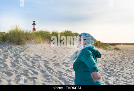 Deutschland, Sylt, Nordsee, Frau bei einem Spaziergang am Sandstrand Stockfoto