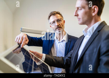 Zwei Geschäftsleute in Office mit Solarzelle diskutieren Stockfoto