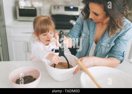 Mutter und Tochter gemeinsam einen Kuchen machen Stockfoto