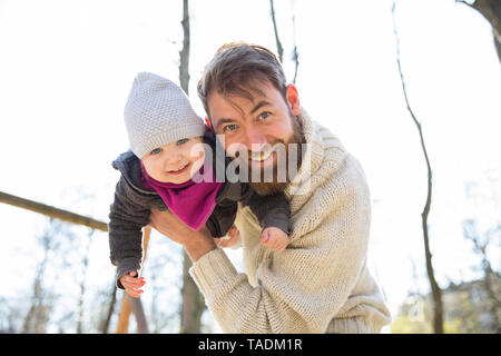 Porträt der glückliche Vater Holding Tochter in Park Stockfoto