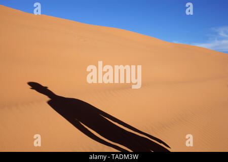Marokko, Merzouga, Erg Chebbi, Schatten der Mann mit dem Hut in der Wüste Düne Stockfoto