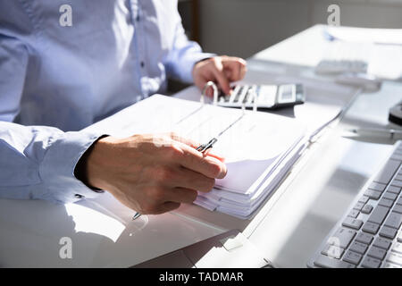 Unternehmer Berechnung Rechnung mit Rechner am Schreibtisch Stockfoto