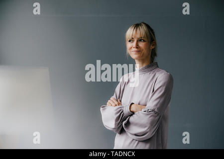 Porträt einer zuversichtlich, blonde Frau mit verschränkten Armen Stockfoto