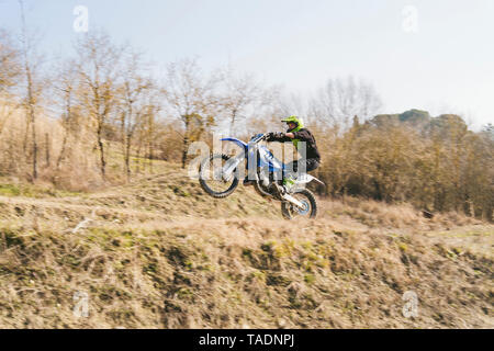 Motocross Fahrer Reiten am Stromkreis tun einen Wheelie Stockfoto