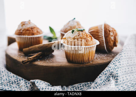 Home gebackene Muffins mit Zimt und Minze auf Holzbrett Stockfoto