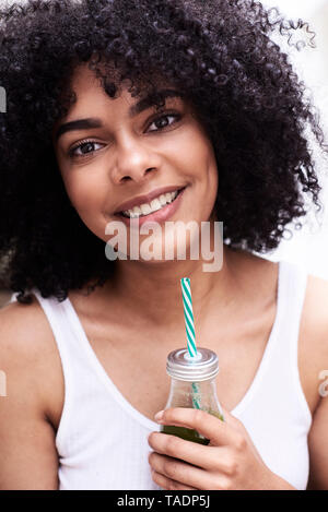 Portrait von lächelnden schöne junge Frau mit grünen gesunden Smoothie Stockfoto