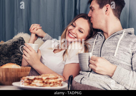 Liebevolle junge Paar Frühstück im Bett Stockfoto