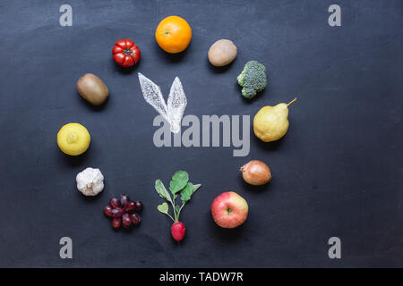 Obst und Gemüse buliding Uhr auf dunklem Boden mit Stockfoto
