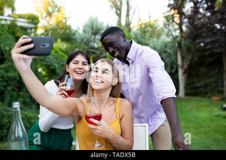 Freunde Spaß an einem Sommer Abendessen im Garten, unter selfies Stockfoto