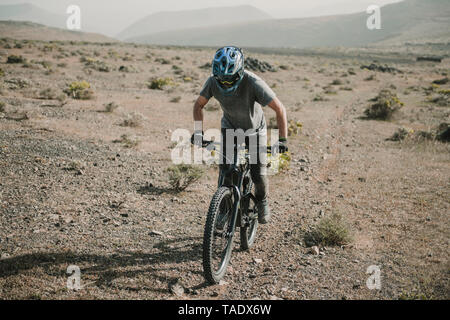 Spanien, Lanzarote, Mountainbiker auf einer Reise in Wüstenhaft Landschaft Stockfoto