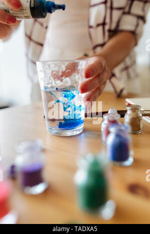 Maler Füllflüssigkeit Farbe ins Glas Wasser, Teilansicht Stockfoto