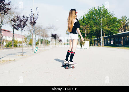 Spanien, junges Mädchen reiten Skateboard auf einer Straße Stockfoto