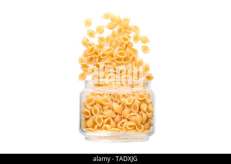 Pasta in Glas Glas auf weißem Hintergrund. Ungekocht Vollkornnudeln Stockfoto