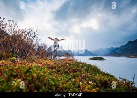 Norwegen, Lofoten, Mann an der Küste springen Stockfoto