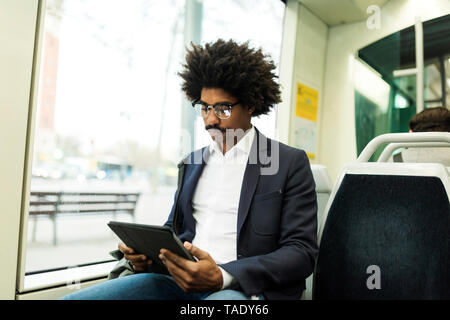 Spanien, Barcelona, Geschäftsmann, der in einer Tablette Straßenbahn Stockfoto
