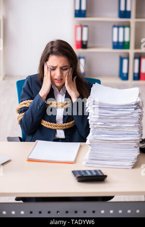 Junge schöne Mitarbeiter gebunden mit Seil im Büro Stockfoto