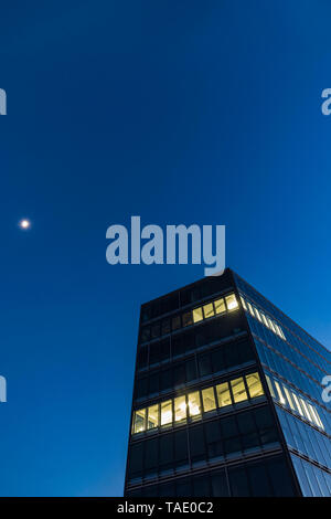 Deutschland, Stuttgart, Windows an modernen Bürogebäude an der blauen Stunde beleuchtet Stockfoto