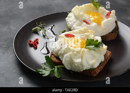 Zarte gebackenes Ei. Orsini Eier in der Cloud. Französisches Frühstück. Cloud Ei auf Toast Stockfoto