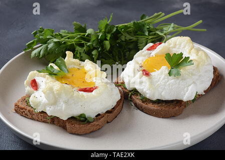 Zarte gebackenes Ei. Orsini Eier in der Cloud. Französisches Frühstück. Cloud Ei auf Toast Stockfoto