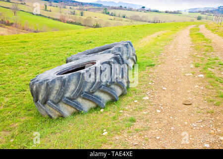 Paar Reifen eines großen Traktor zerlegt und in einem Italienischen Landstraße links Stockfoto