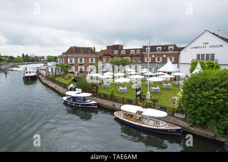 Macdonald Compleat Angler Hotel Essbereich im Freien auf Rasen mit Tischen, Stühlen, Sonnenschirmen. Kleine Boote auf dem Fluss Themse günstig neben. Stockfoto