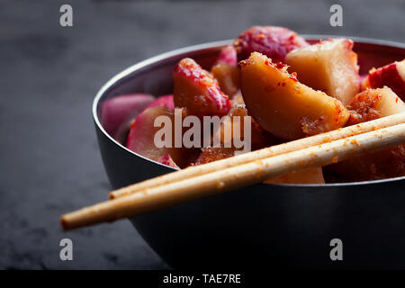 Kimchi Rettich in einer süßen und würzigen Beizen sauce Kkakdugi close-up. Traditionelle koreanische knackig würzig fermentiertes Gemüse in der Schüssel Stockfoto